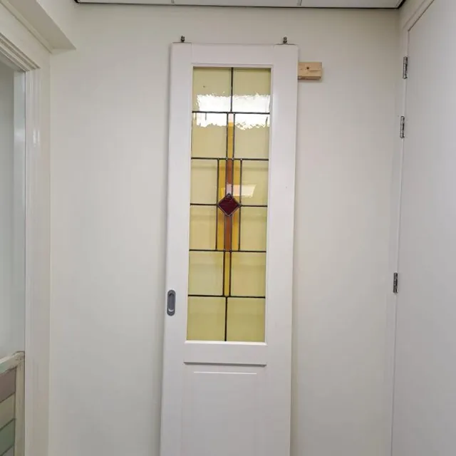 Gerestaureerde ensuitedeur met glas in lood in amber en een kleine rode ruit