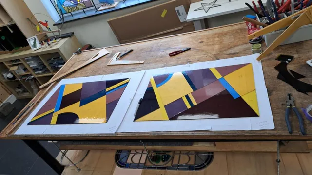 Gesneden stukken gekleurd glas liggen op het patroon op de werktafel