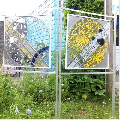 Tweeluik van glas-in-loodpanelen met confetti-motief in een tuin