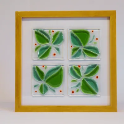 Vier groene glasfusing-bladeren in een houten lijst