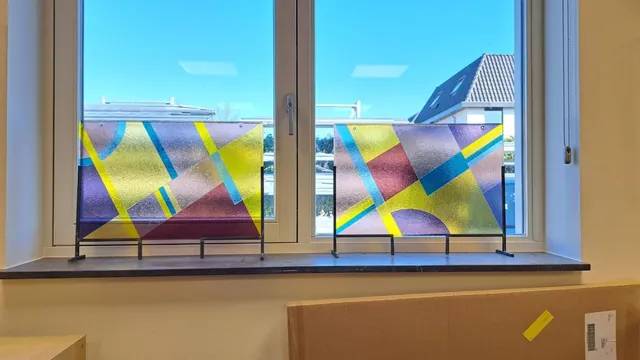 De twee afgewerkte glas-in-loodpanelen voor een raam in het atelier