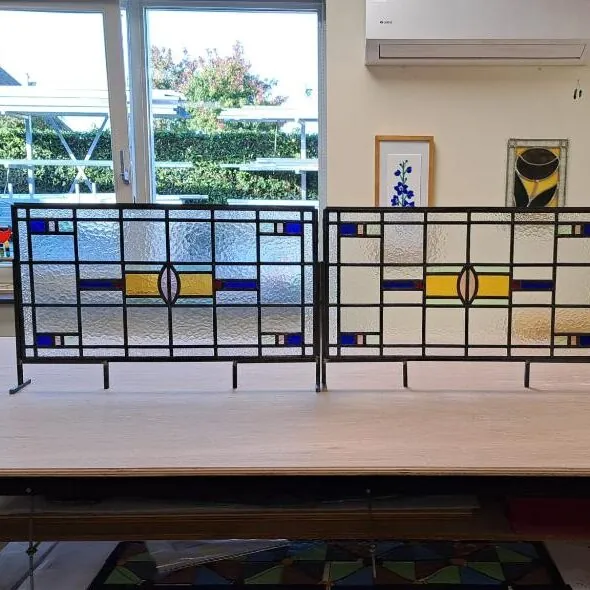 Glas-in-loodpanelen voor een raam met gele, blauwe en groene accenten