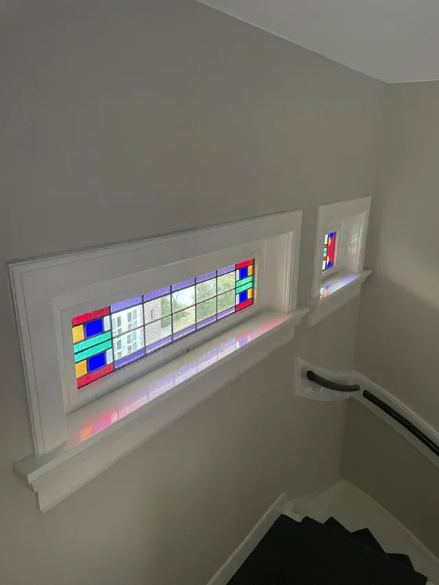 Glas-in-loodramen op een overloop met lichte en gekleurde vlakken